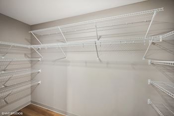 the spacious walk in closet in the master bedroom has shelves and wire shelving